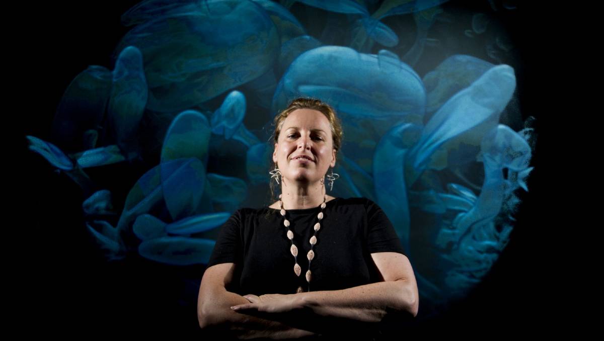 Erica Seccombe in front of Out of Season, a stereoscopic projection installation of a germinating Mung Bean. 2015