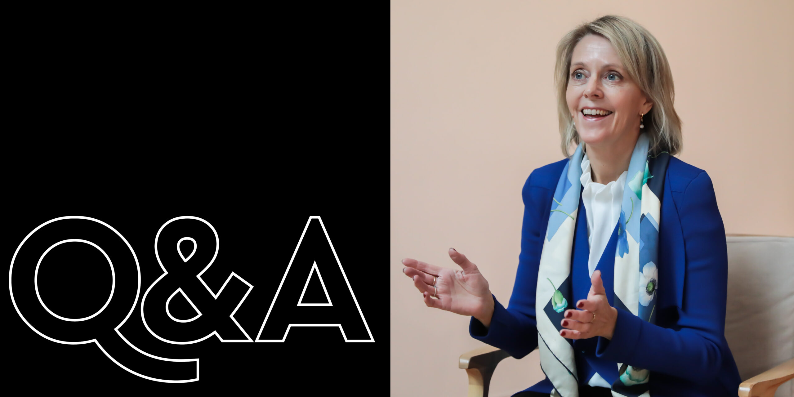 Left half shows a black background with large white outlined 'Q&A' text; right half features a smiling woman in a blue blazer and floral scarf speaking, gesturing with hands in a seated interview setting.